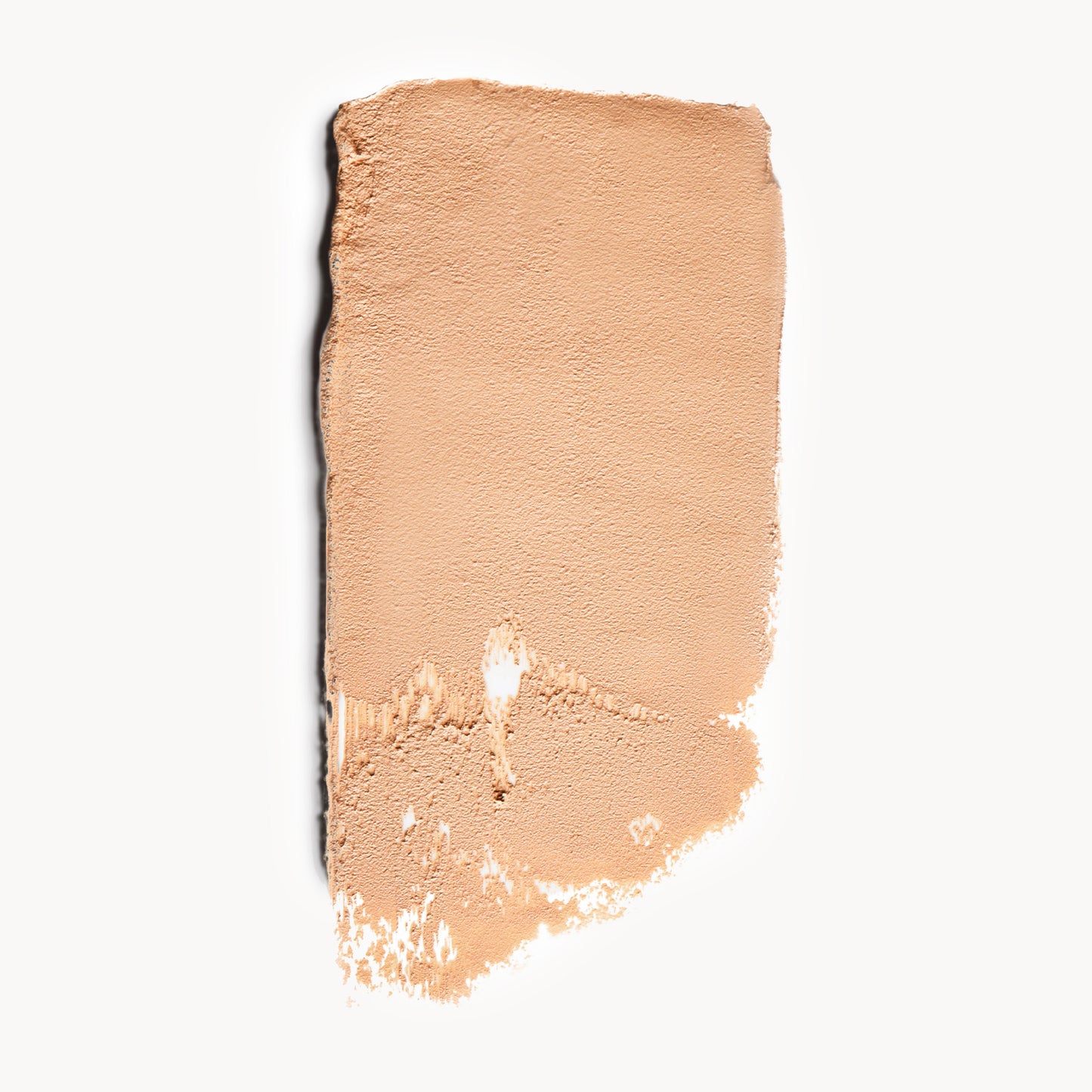 A wipe of light, neutral-toned cream foundation on a white background