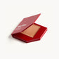 A red KW palette with the lid open to show the cream glow