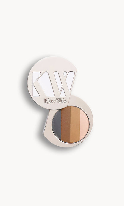 Solid metal KW palette with lid open to show a circle of eye shadow split into four shades