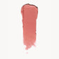 A wipe of soft coral cream blush on a white background 