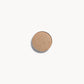 A circle of warm beige eye shadow on a white background