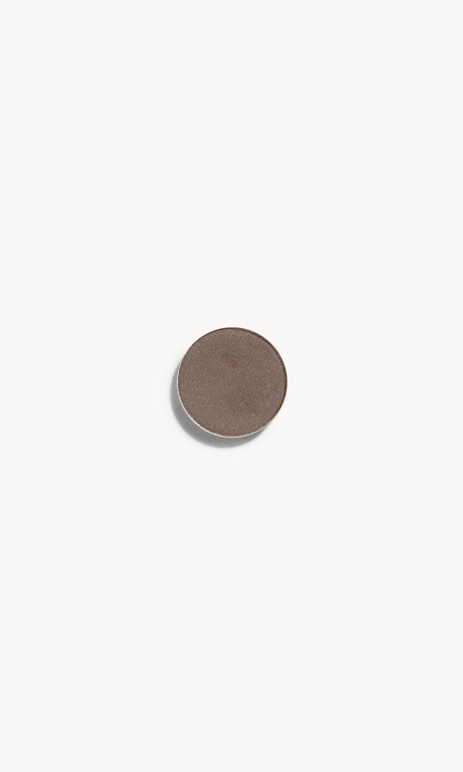 a circle of greyish brown eye shadow on a white background