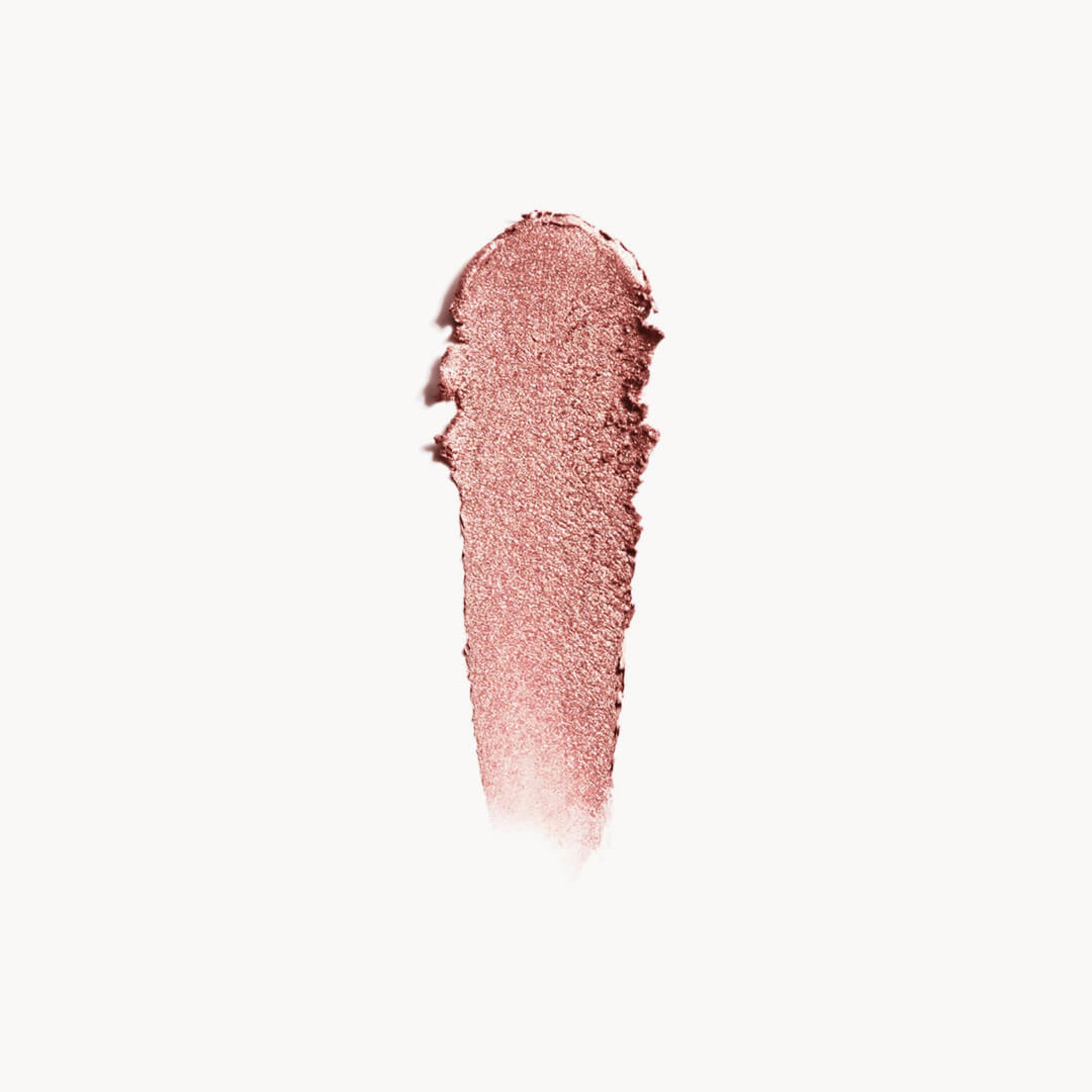 A wipe of iridescent rose gold eye shadow on a white background