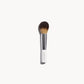 Makeup brush with white and silver handle and large rounded bristles on a white background