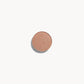 A circle of iridescent champagne pink eye shadow on a white background