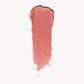 A wipe of soft coral cream blush on a white background