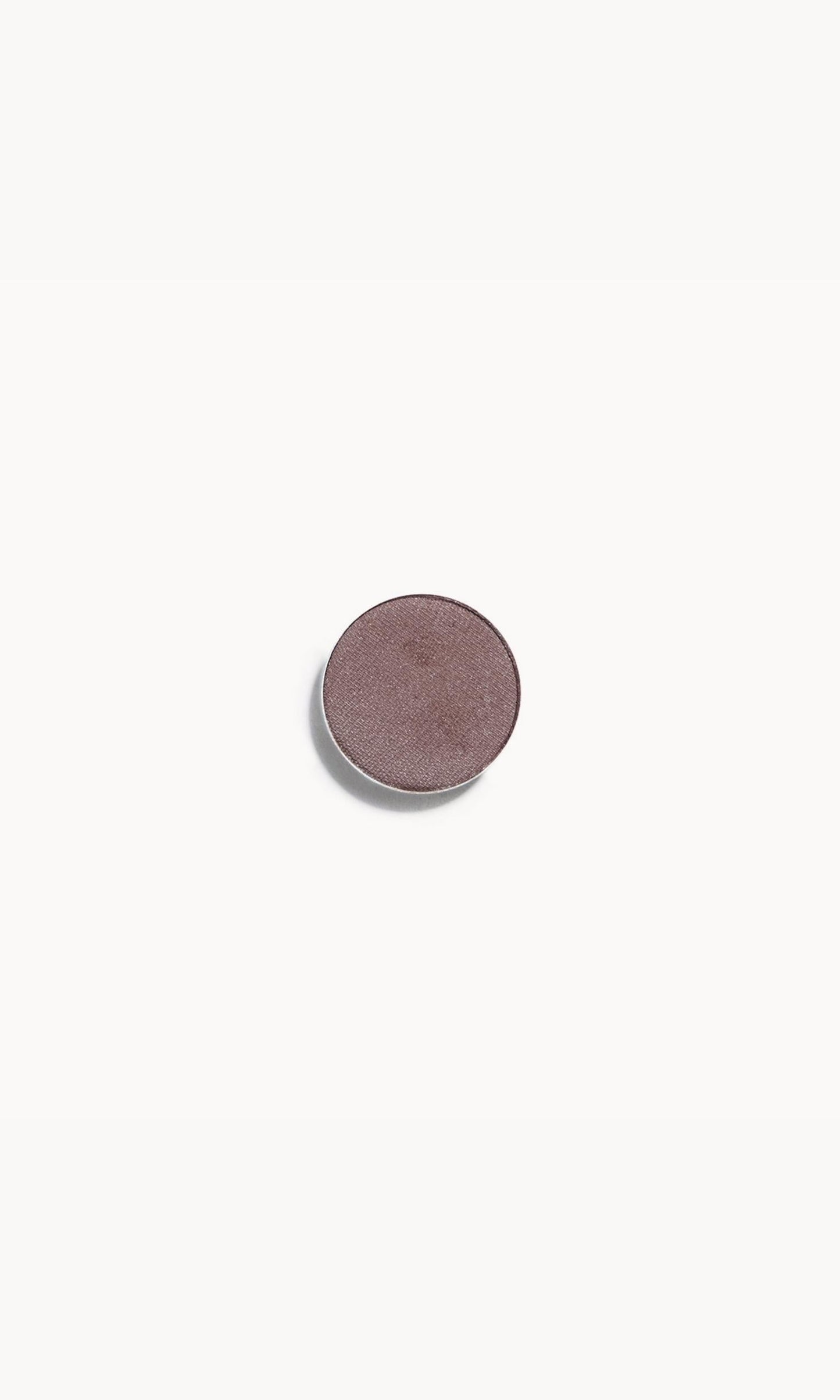 A circle of taupe eye shadow on a white background